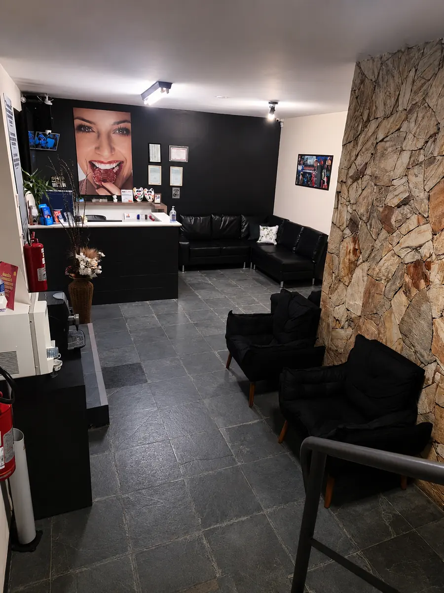 Sala de espera do consultório do Dr. Danilo Menah com poltronas e sofá