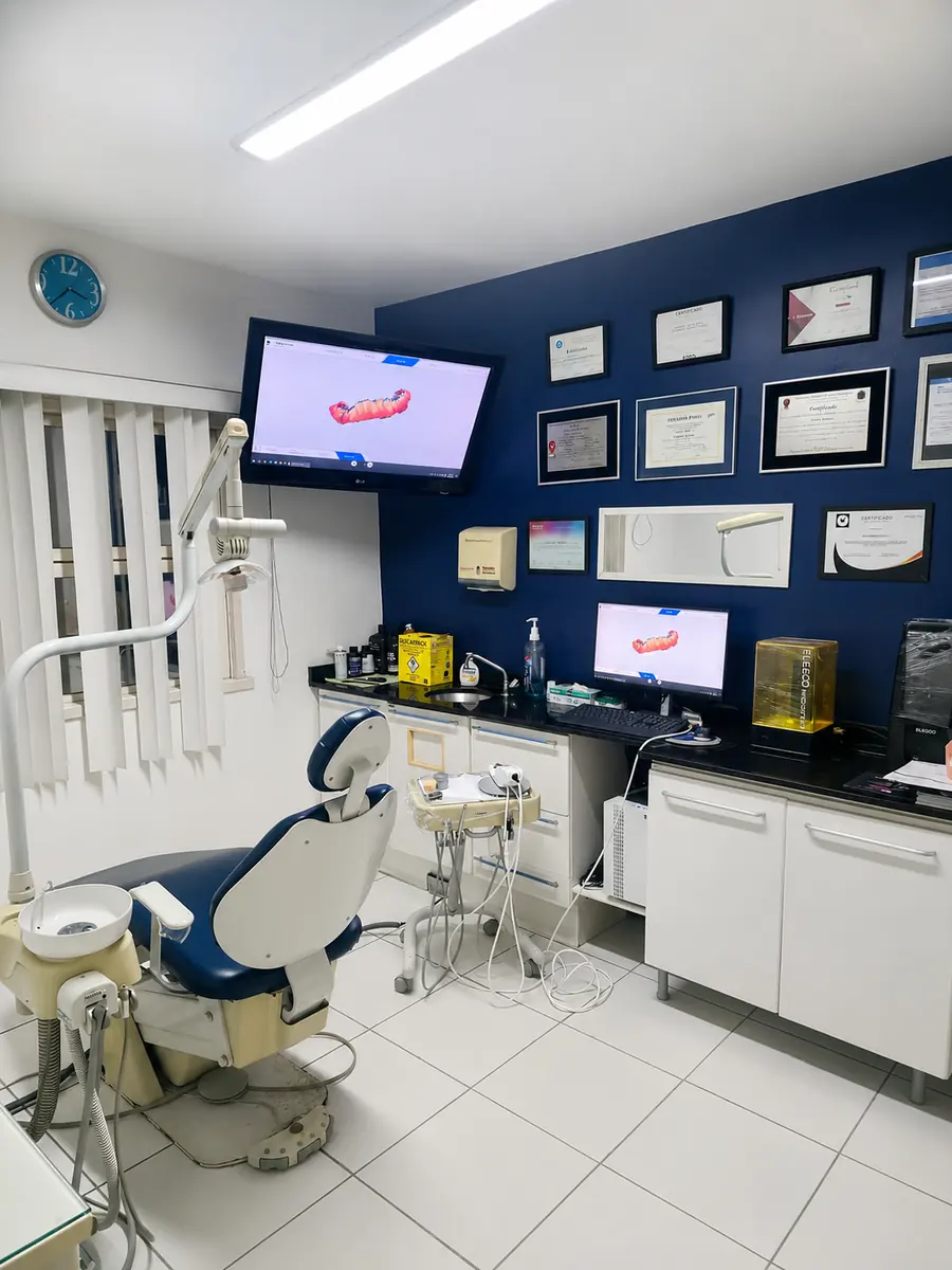 Sala do scanner intraoral 3D do Dr. Danilo Menah com cadeira odontológica e certificados